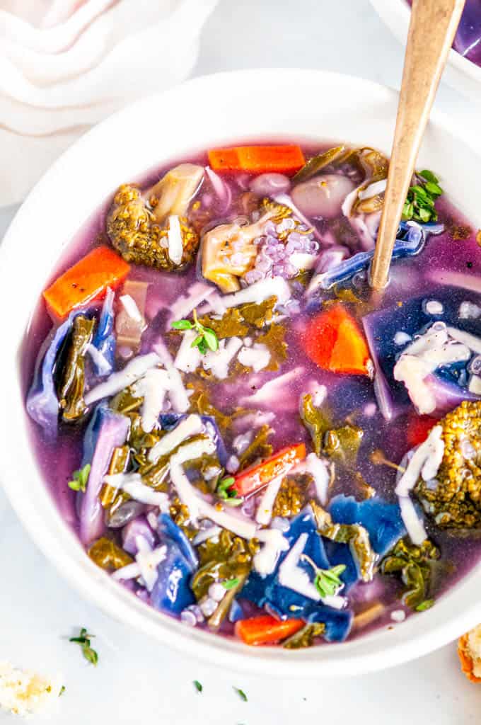 White Bean Purple Cabbage Soup with gold spoon in white bowl close up