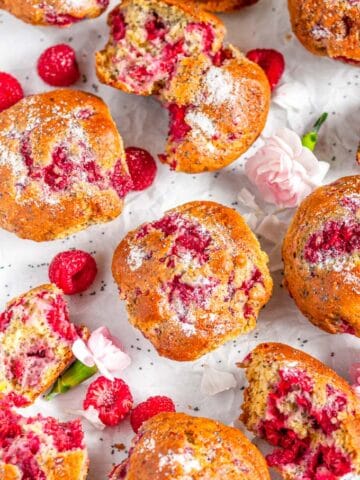 Raspberry Poppy Seed Muffins with pink and white flowers on parchment