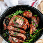 Rib Eye Steak with Red Wine Shallot Compound Butter and herbs sliced in cast iron skillet