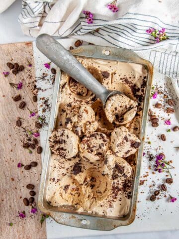 No Churn Chocolate Chunk Coffee Ice Cream with scoop on white marble with flowers