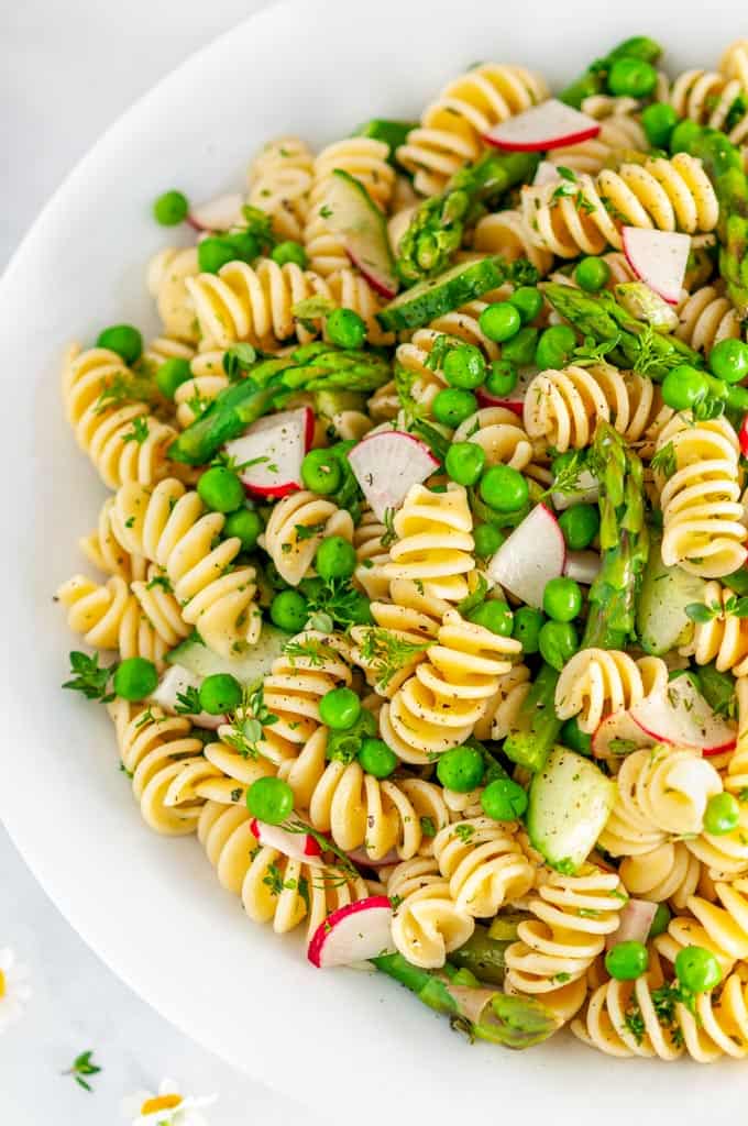 Springtime Vegetable Pasta Salad in white bowl on marble close up
