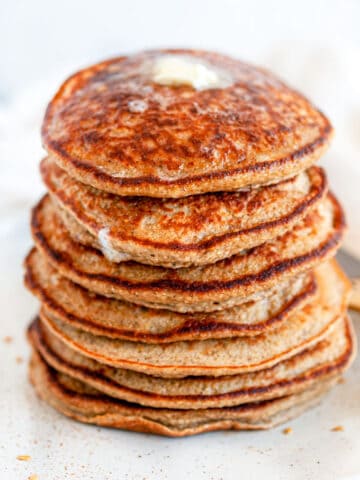 Fluffy Banana Oat Pancakes (Gluten Free) stack with butter on top side view close up