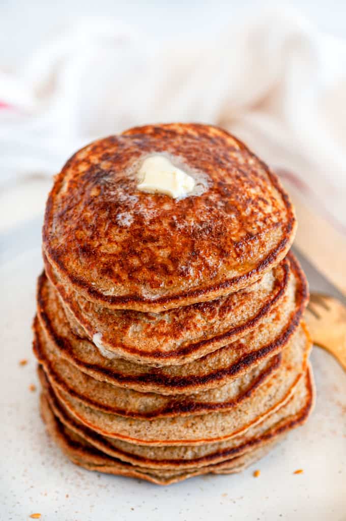 Fluffy Banana Oat Pancakes (Gluten Free) stack with butter on top\ with gold fork overhead