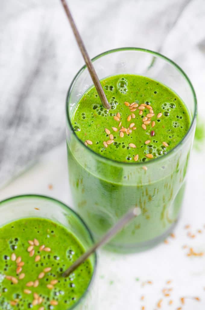 Green Tea Matcha Smoothie in tall glasses with flax seeds and silver spoons over head