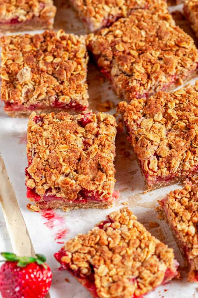 Strawberry Rhubarb Crumble Bars on parchment and white marble sliced
