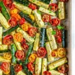 Roasted Parmesan Zucchini and Tomatoes on a gray rimmed baking sheet over head view