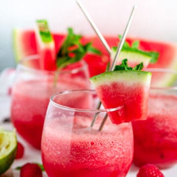 Sparkling Watermelon Raspberry Slushie Cocktail (Pitcher Recipe) in stemless wine glasses on white marble side view