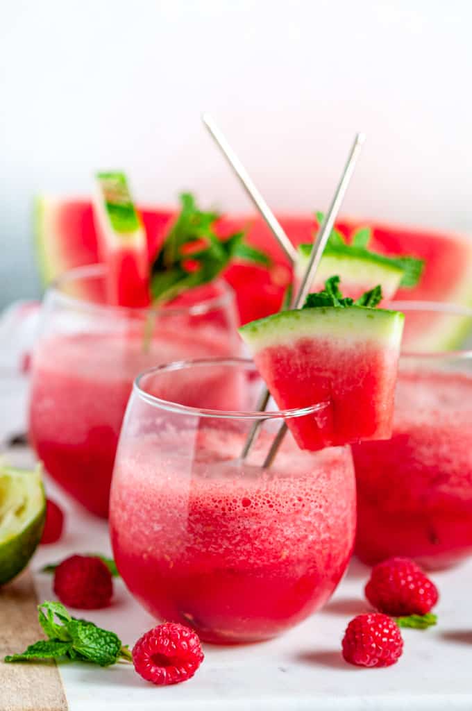 Sparkling Watermelon Raspberry Slushie Cocktail (Pitcher Recipe) in stemless wine glasses on white marble side view