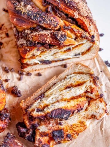 Chocolate Chunk Pumpkin Babka loaf sliced on parchment paper and white marble