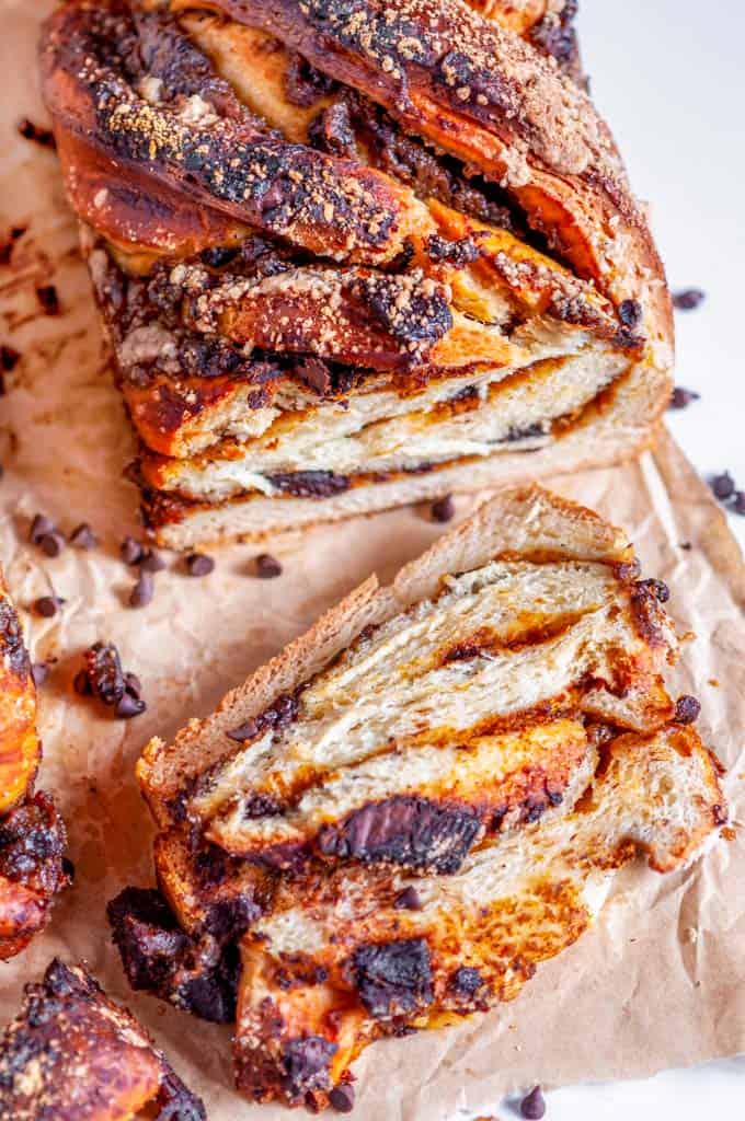 Chocolate Chunk Pumpkin Babka loaf sliced on parchment paper and white marble