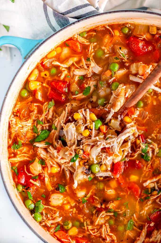 Loaded Chicken Hominy Soup in blue le creuset dutch oven with wood spoon