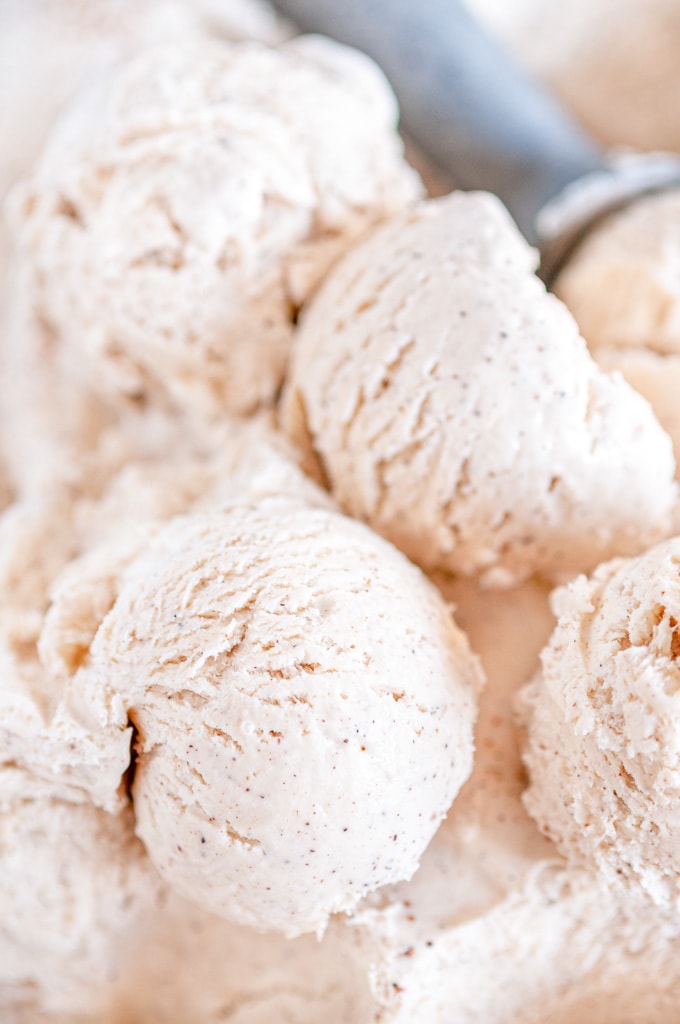 No Churn Egg Nog Ice Cream scooped into balls with gray scoop in bread pan