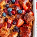 Baked Overnight Berry French Toast in white casserole dish on wire rack close up
