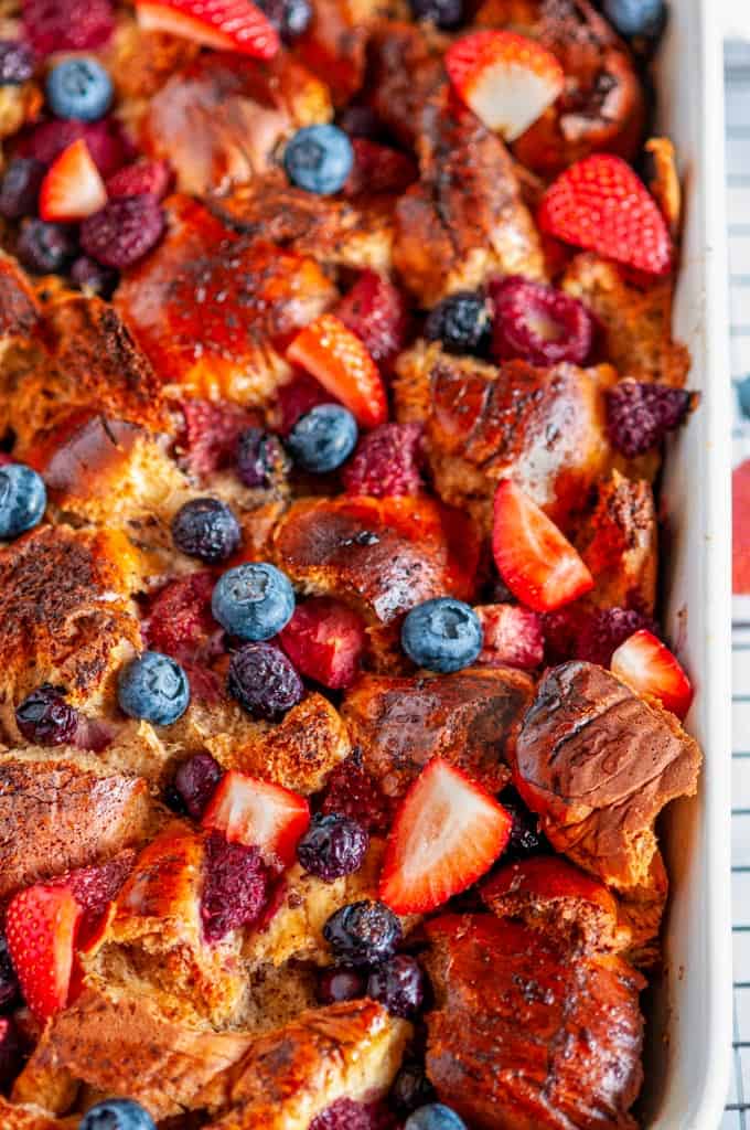 Baked Overnight Berry French Toast in white casserole dish on wire rack close up