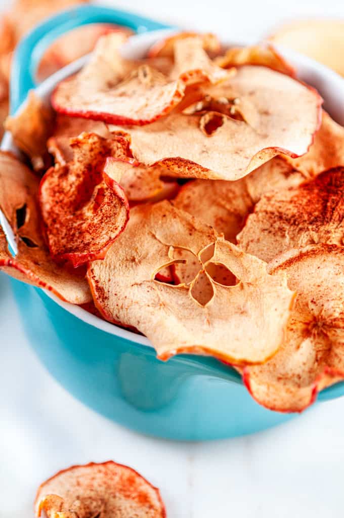 Healthy Baked Apple Chips in mini aqua blue cocette on white marble close up