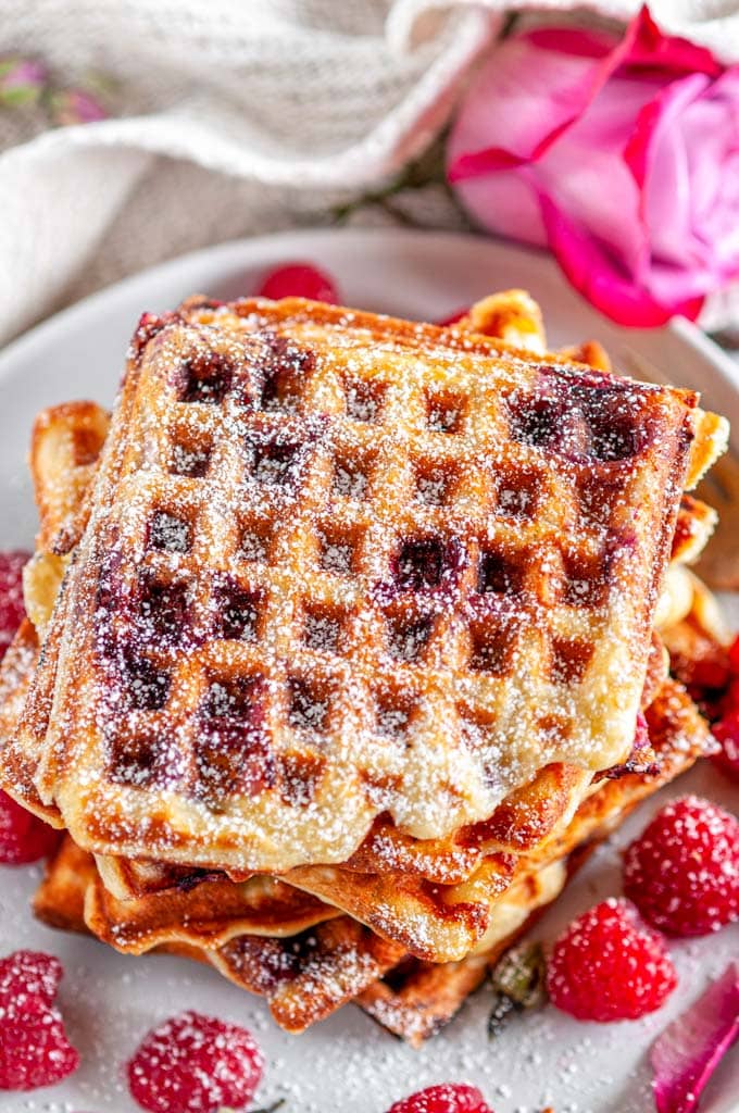 Lemon Raspberry Buttermilk Waffles stack with rose buds and petals on gray plate and white marble