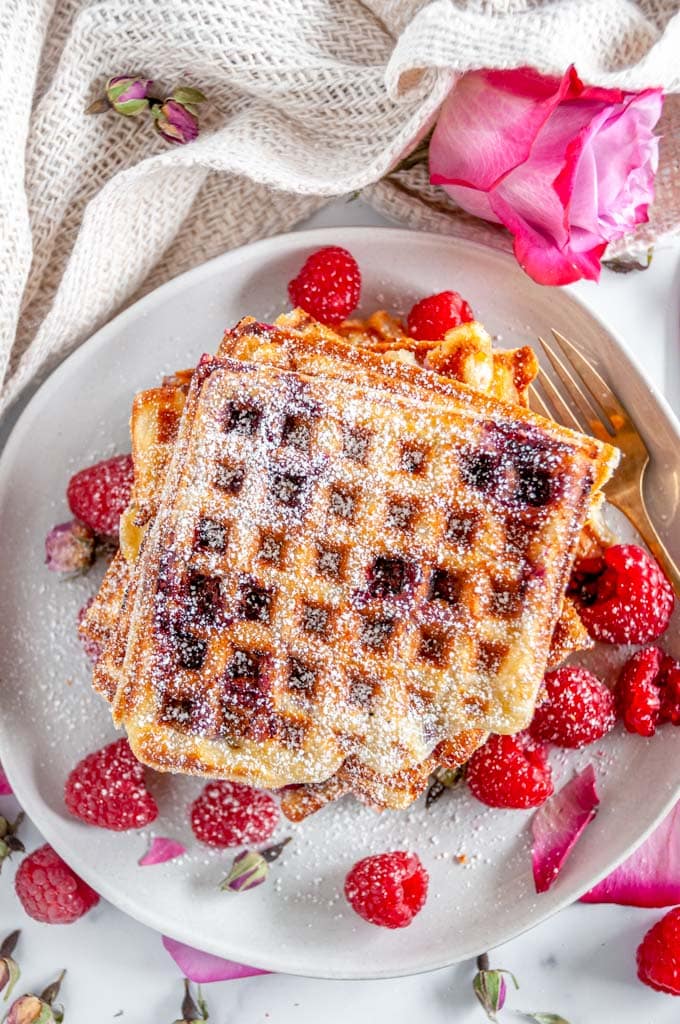 Lemon Raspberry Buttermilk Waffles stack with rose buds and petals on gray plate and white marble