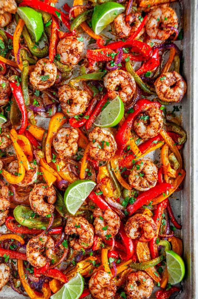 Sheet Pan Shrimp Fajitas with limes and bell peppers on baking pan