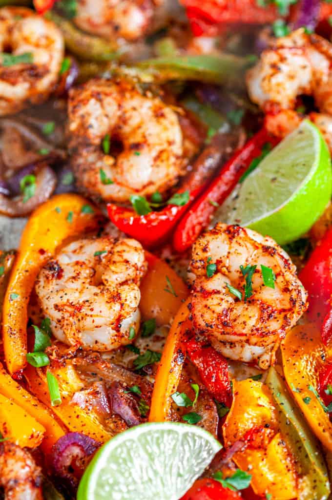 Sheet Pan Shrimp Fajitas with limes and bell peppers on baking pan close up