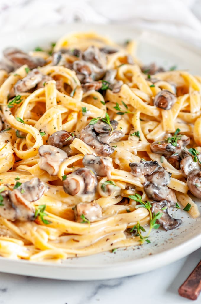 Date Night Mushroom Fettuccine Alfredo on gray plate and white marble close up