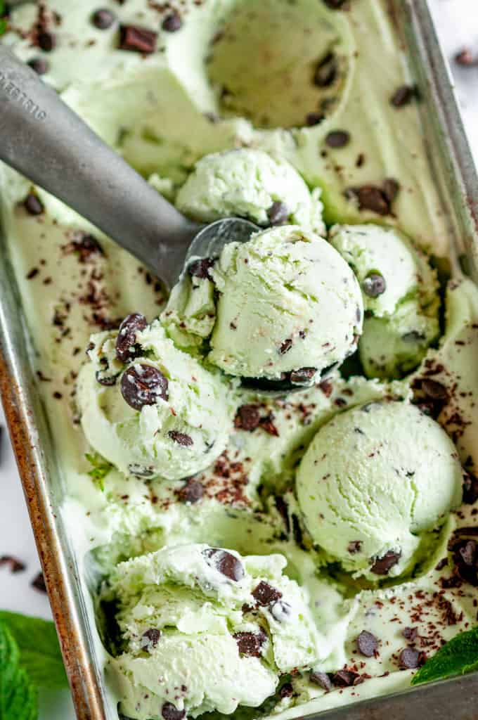 No Churn Mint Chocolate Chip Ice Cream with scoop in silver bread pan on white marble
