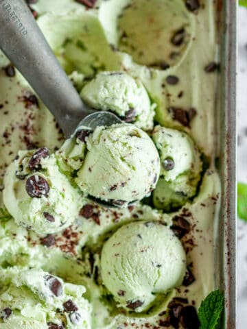 No Churn Mint Chocolate Chip Ice Cream with scoop in silver bread pan on white marble