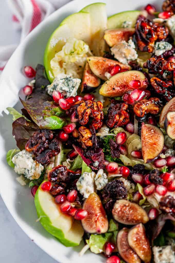 Fall Harvest Salad with Homemade Candied Walnuts in white bowl with tea towel on white marble