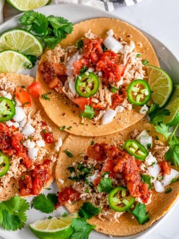 Easy Instant Pot Chicken Tacos on gray plate and white marble with fixings