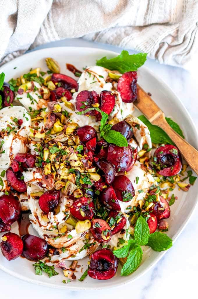 Balsamic Cherry Mint Burrata with pistachios on white plate