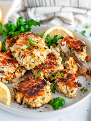Pan Fried Cod Crab Cakes on gray plate with parsley and lemon slices