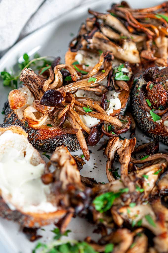 Easy Roasted Herb Mushrooms with buttered baguette slices on gray plate