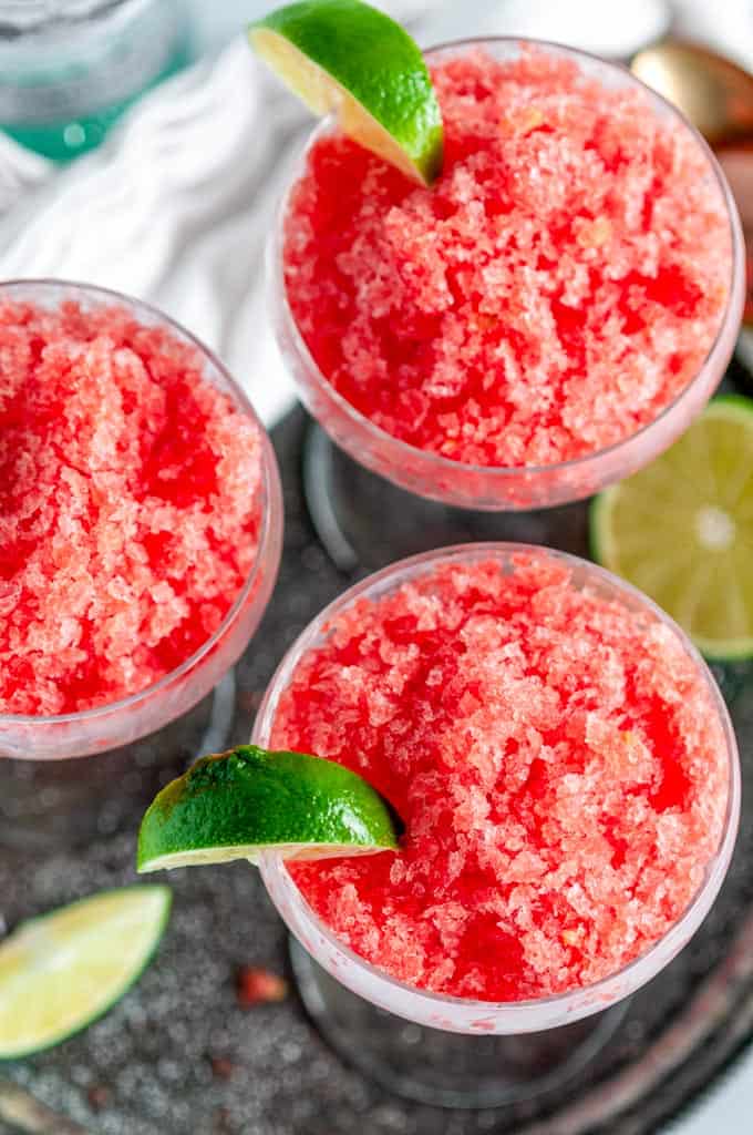 Summertime Boozy Watermelon Granita in china glasses with lime slice on gray plate