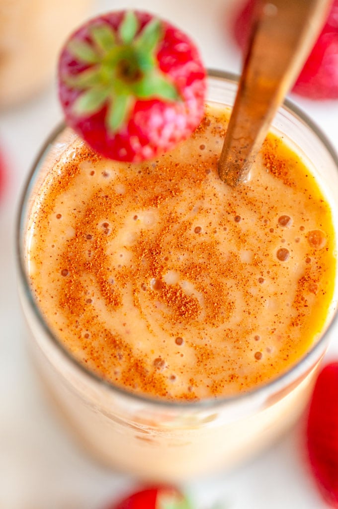 Strawberry Banana Pumpkin Smoothie ing lass with gold spoon on white marble