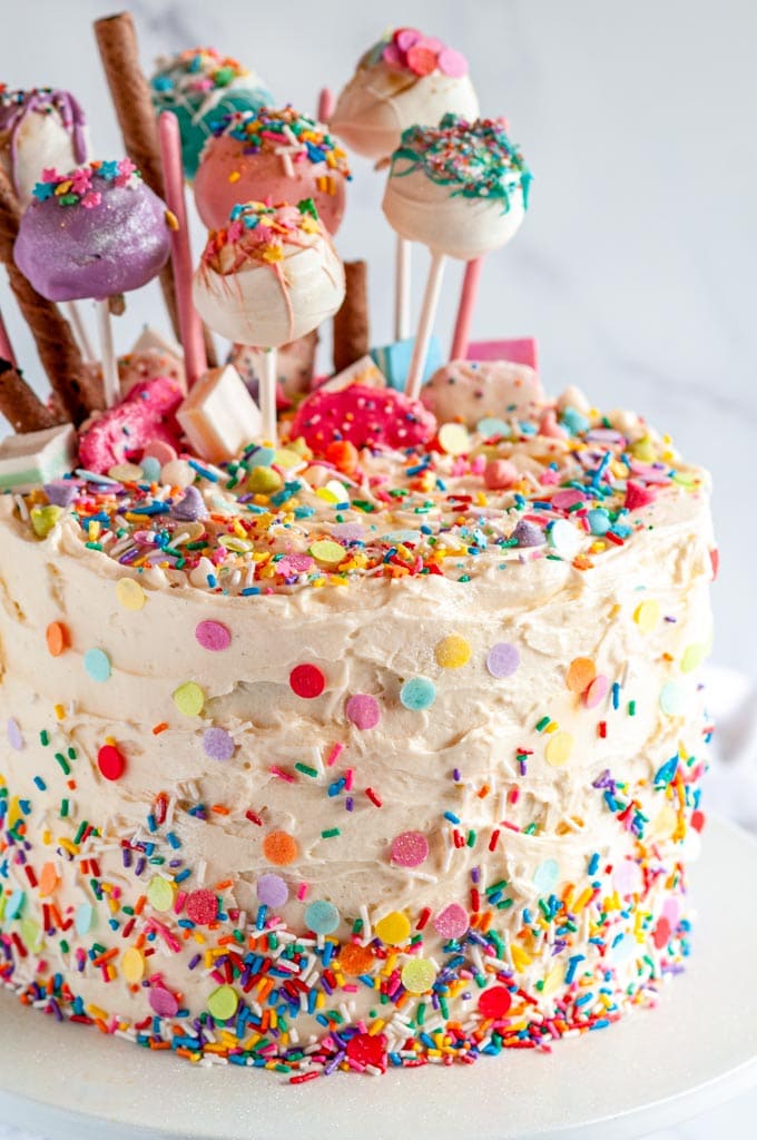 Birthday Surprise Confetti Cake with cake pops on white cake stand 