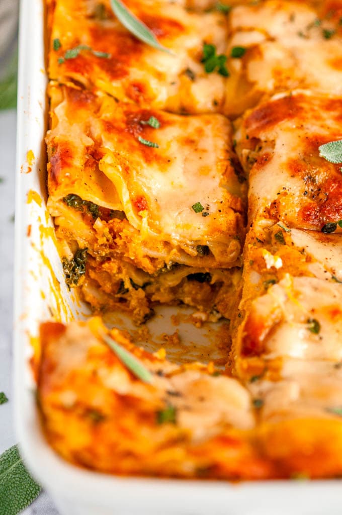 Butternut Squash Vegetable Lasagna in white casserole dish with slice removed