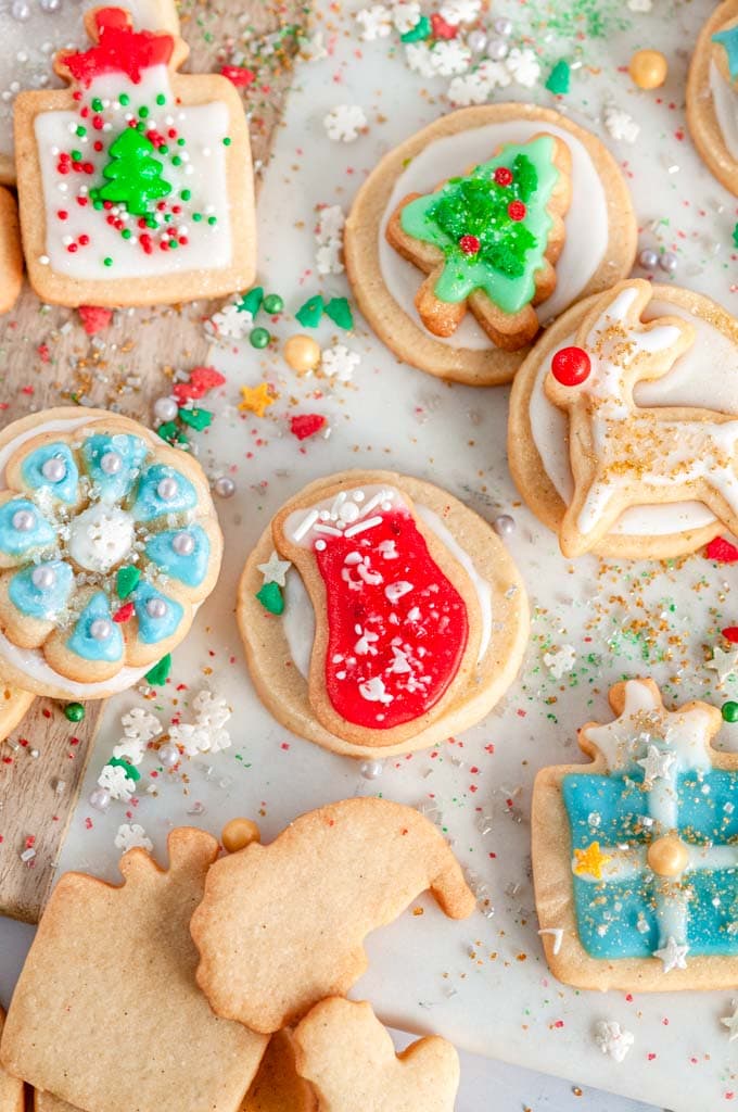 Holiday Sugar Cookies with Vanilla Icing with sprinkles on white marble