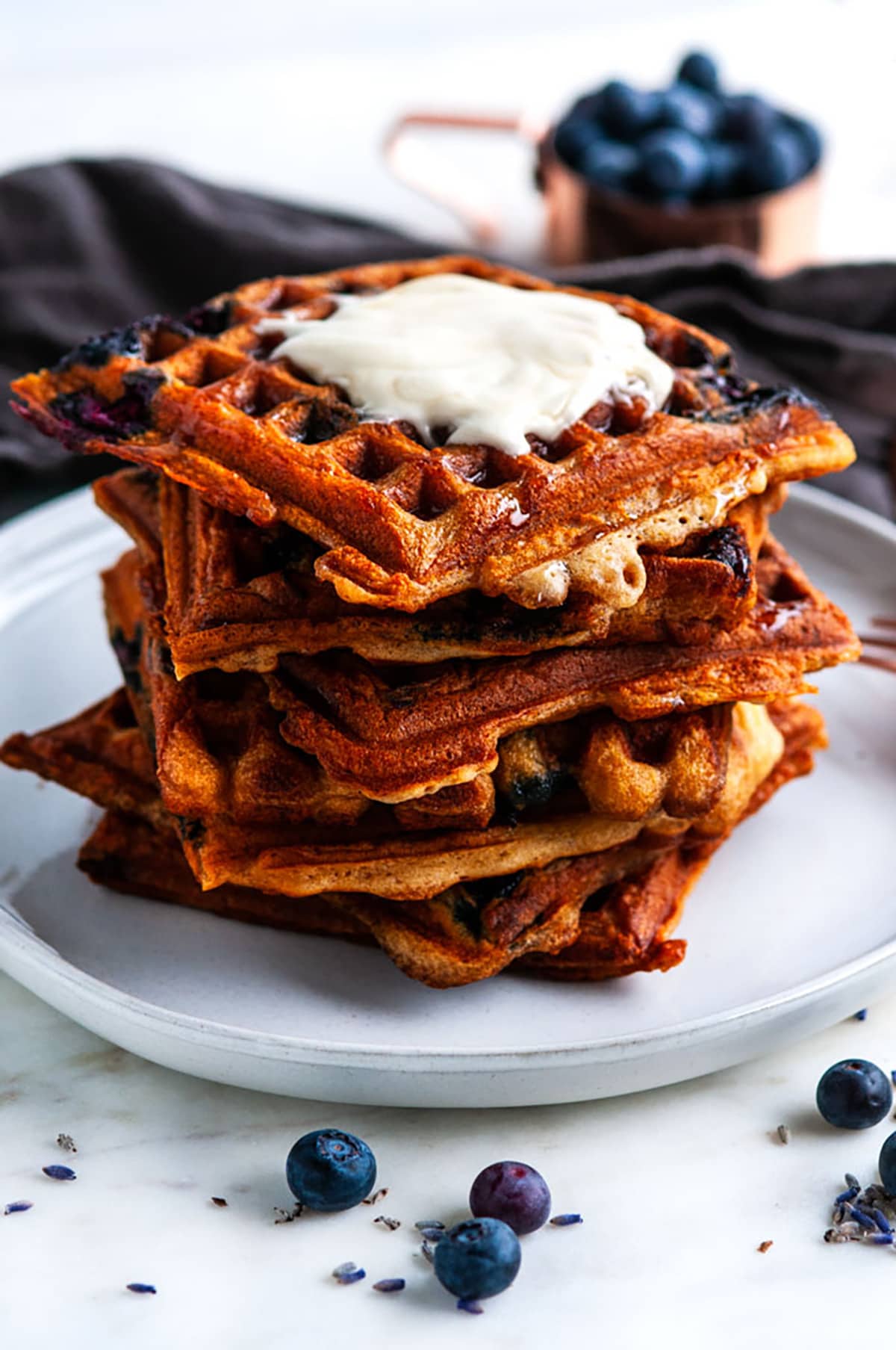 London Fog Blueberry Waffles with copper silverware and gray tea towel
