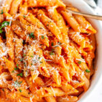 Easy Penne Alla Vodka in white bowl with gold spoon close up