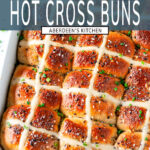 Everything Bagel Hot Cross Buns in white baking dish with sliced chives on white marble overhead view with teal rectangle and white text overlay