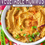 Easy Roasted Vegetable Hummus in white bowl topped with microgreens and surrounded by fresh veggies on white marble close up overhead view - purple rectangle with white text overlay
