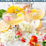 Sparkling Suze Wildflower Cocktail in crystal glasses with edible flowers on white marble - translucent teal rectangle layered on top with white font