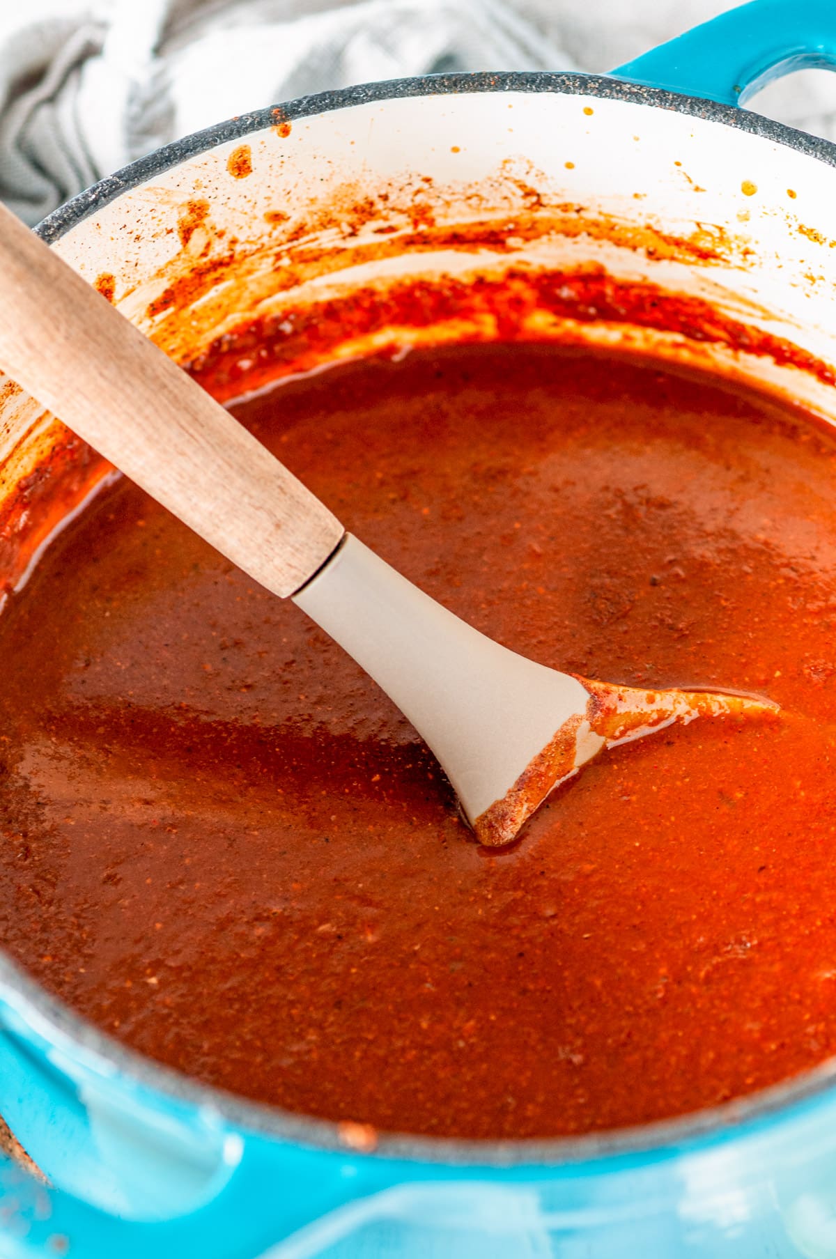 Pantry Friendly Enchilada Sauce in blue enameled saucepan with gray spoon
