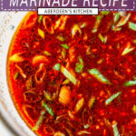 Korean BBQ Marinade whisked together in glass bowl on white marble with green onion and sesame seeds close up - purple rectangle overlay with white text