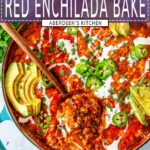 One Pot Red Enchilada Bake with scoop in wooden serving spoon topped with sliced avocado, jalapeno, cilantro, and crema Mexicana