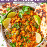 Lentil Chickpea Veggie Curry in metal bowl with limes, cilantro and fresh naan bread on white marble - purple rectangle with white text overlay