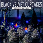 Black velvet cupcakes topped with sanding sugar and sprinkles on gray metal plate with purple lights, candles, and eerie forest window moonscape in background - black rectangle with white text overlay