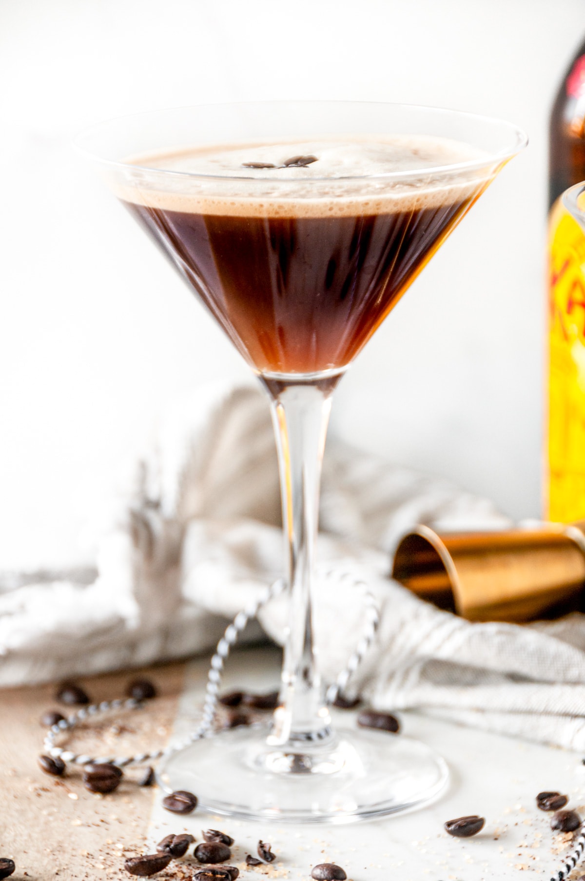 Espresso martini cocktail in glass close up with kahlua bottle in the background