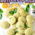 Lemon Basil Butter Cookies on white marble with sliced lemons and fresh basil leaves overhead view - overlaid with purple rectangle and white text stating title