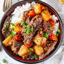 Slow cooker Hawaiian pot roast with pineapple chunks in soy ginger sauce over rice
