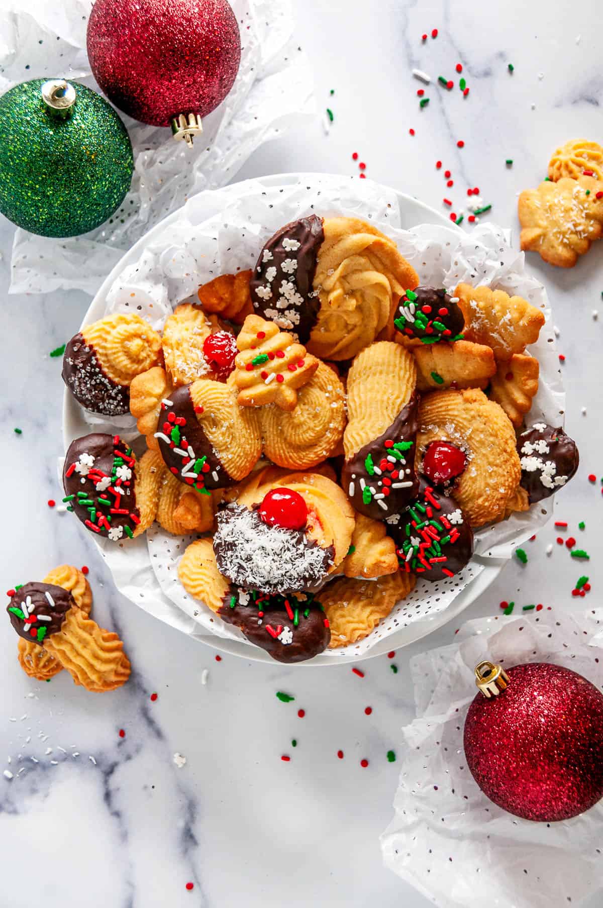 Italian Butter Cookies arranged in a festive bowl with chocolate-dipped cookies, sprinkles, and holiday decorations